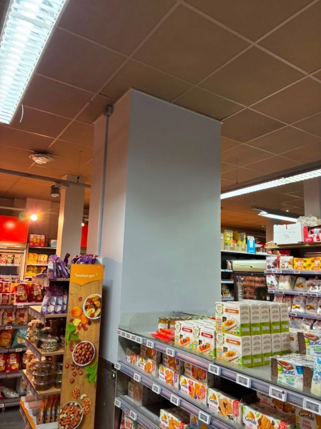 Poteau repris et repeint dans une supérette ouverte
